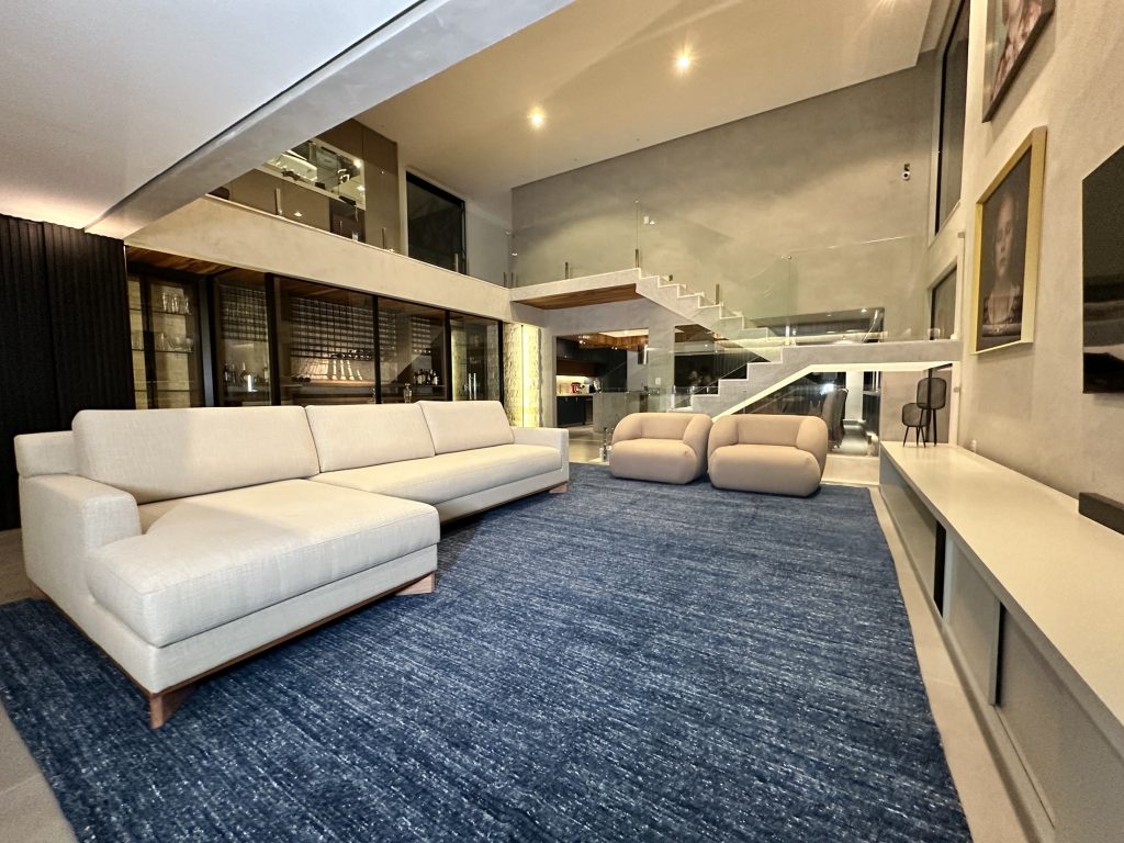Living amplo com sofá claro e marcenaria contemporânea